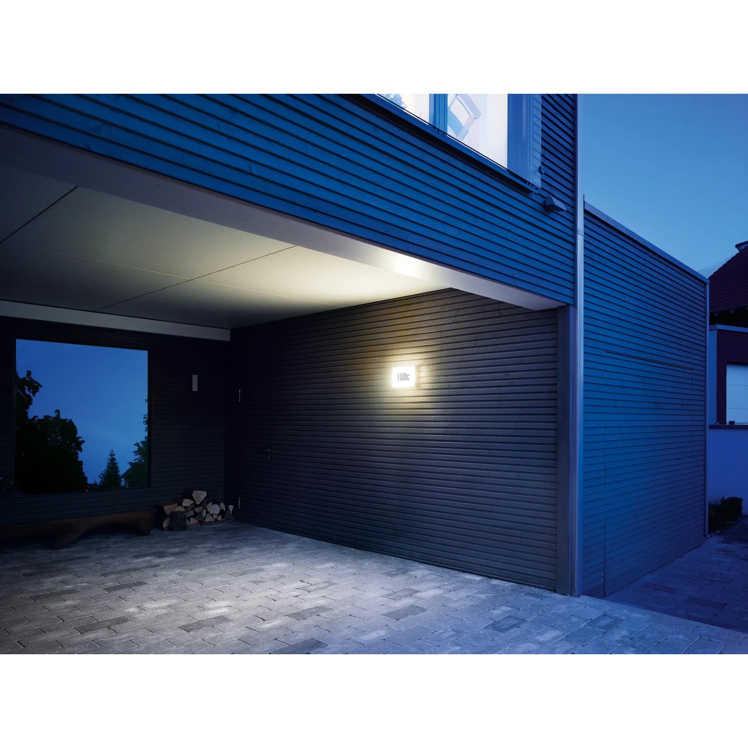 Beleuchtete Steinel LED-Hausnummernleuchte L 1 N an dunkler Hauswand.