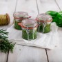 Drei Dr. Oetker Bügelverschlussgläser (135ml) mit Pesto auf weißem Tuch. Küchenhelfer zum Einkochen.