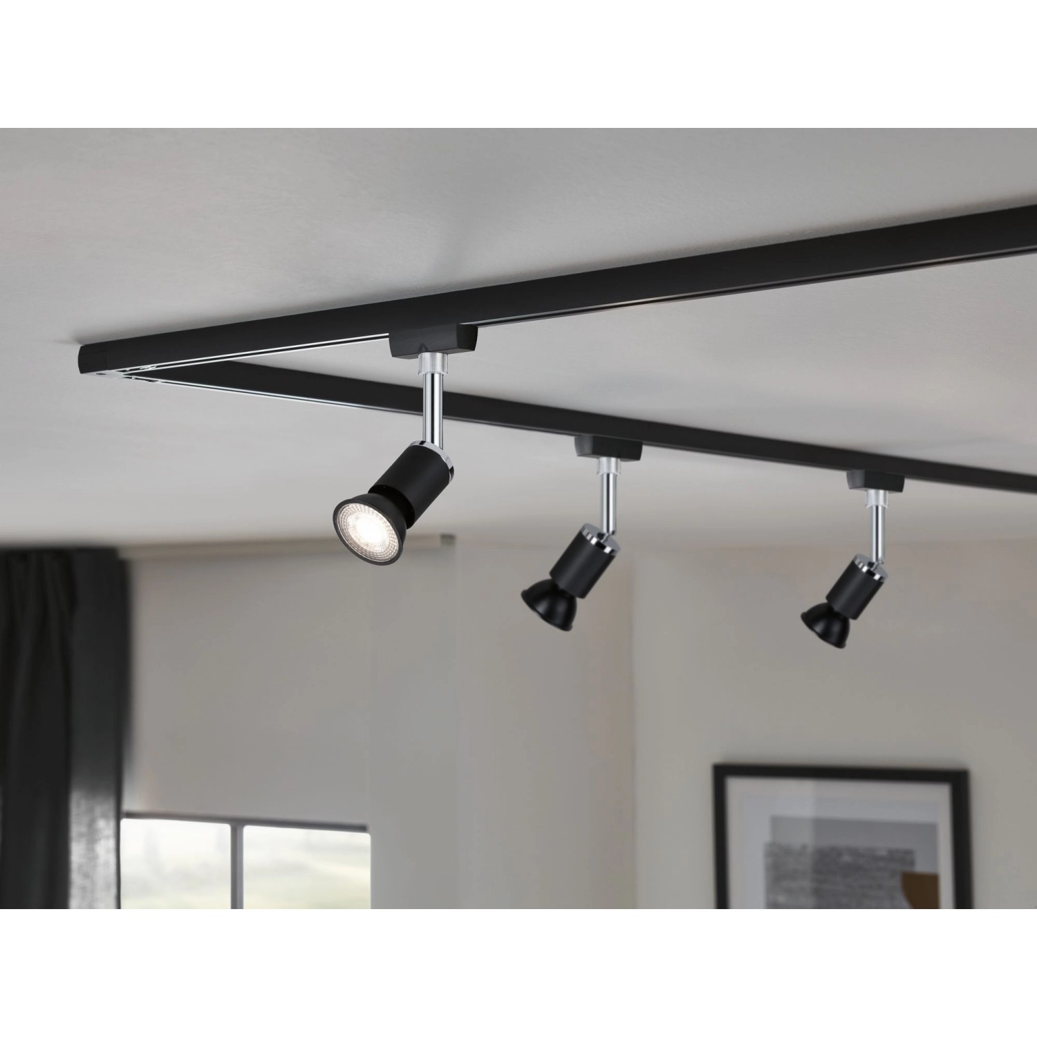 Schienensystem mit drei schwarzen Paulmann LED Reflektorlampen GU10 an der Decke.