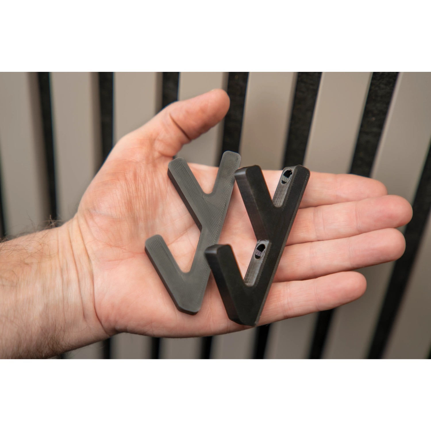 Zwei schwarze 3D Haken zur Befestigung an Denpanels Akustikpaneelen.