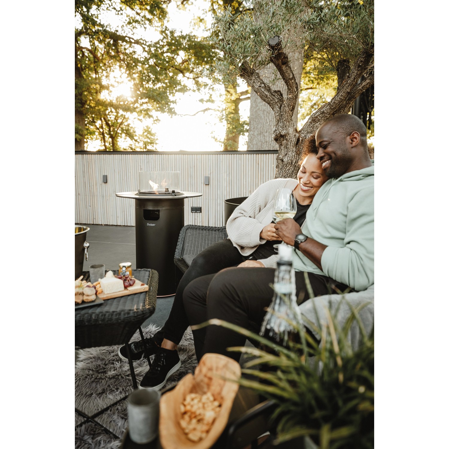 Enders Gas-Terrassenfeuer Nova Schwarz mit Paar beim Entspannen. Stimmungsvolle Terrassenbeleuchtung.