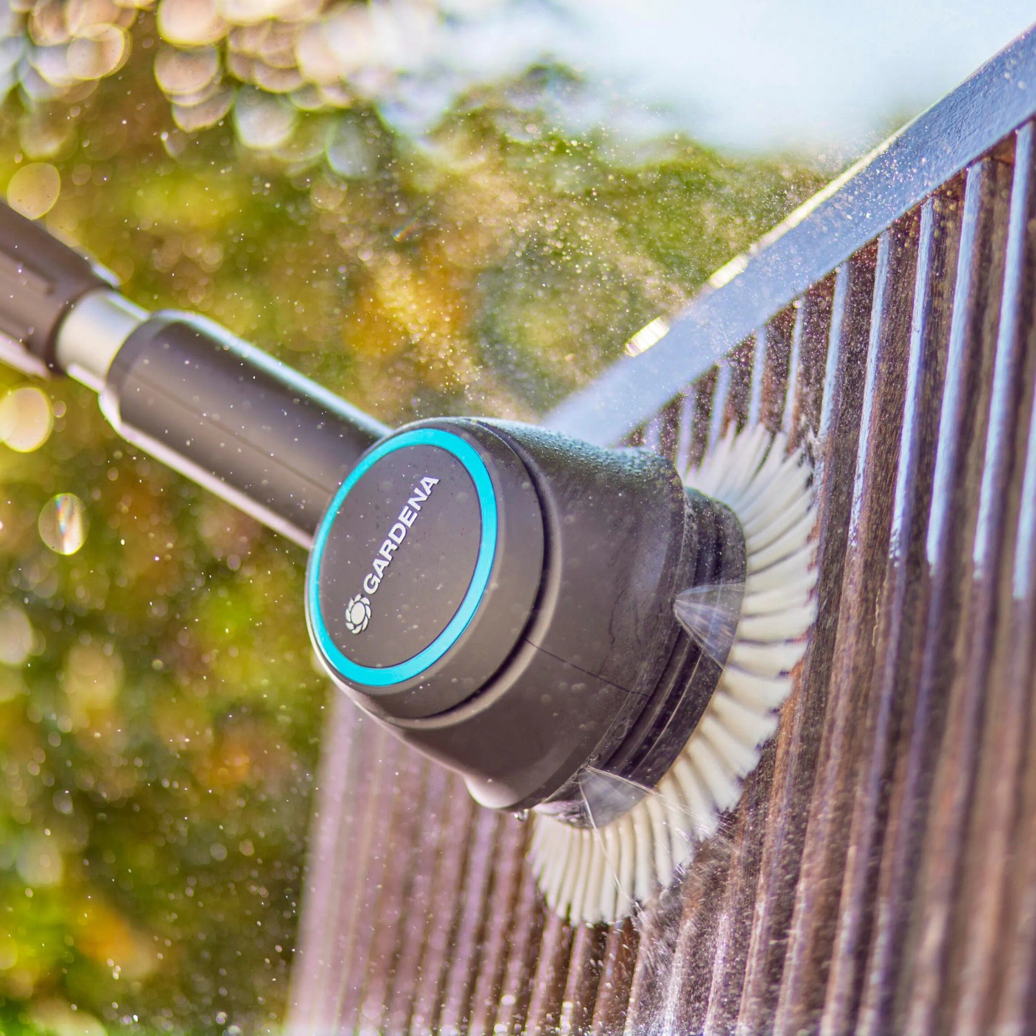 Gardena Akku-Multi-Reiniger AquaBrush im Einsatz: Reinigt Holz mit rotierender Bürste und Wasserzufuhr.