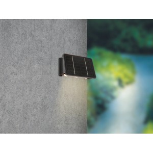 Schwarze LED Solar-Wandleuchte Cariati (17x11x6,5cm) an grauer Wand. Solar-Wandlampe für Aussen.