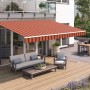 Wismar Gelenkarmmarkise Classic, 300x200 cm, orange-braun, montiert an Hauswand über Terrasse mit Gartenmöbeln.