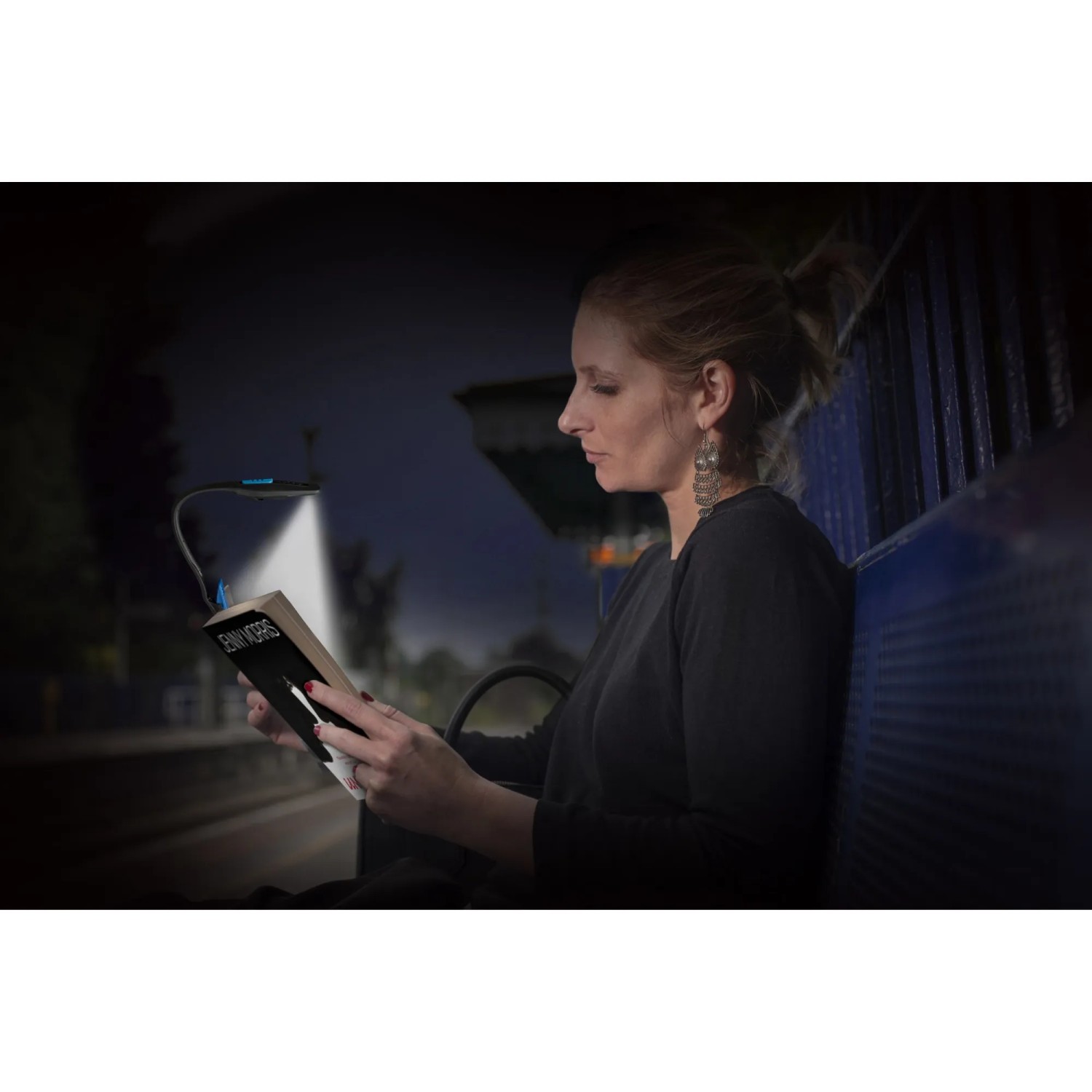 Frau liest Buch mit Energizer Booklight Speziallampe. Flexible LED Leselampe mit Klemme.