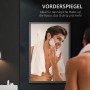 Mann rasiert sich lächelnd im Spiegel eines schwarzen Spiegelschranks im Badezimmer.