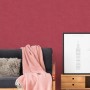 Rote, leicht strukturierte Vliestapete Uni Matt FSC® an einer Wand im Wohnraum.