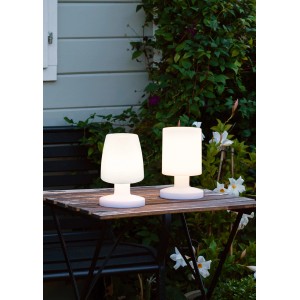 Zwei weiße Reality LED-Tischleuchten Dora für den Außenbereich auf einem Holztisch.