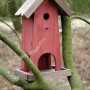 Farbiges Dobar Vogelfutterhaus und Nistkasten aus Holz am Baum.