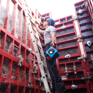 Mann mit HEDI Steckdosenverteiler auf einer Baustelle. Der Verteiler ist schwarz-blau.