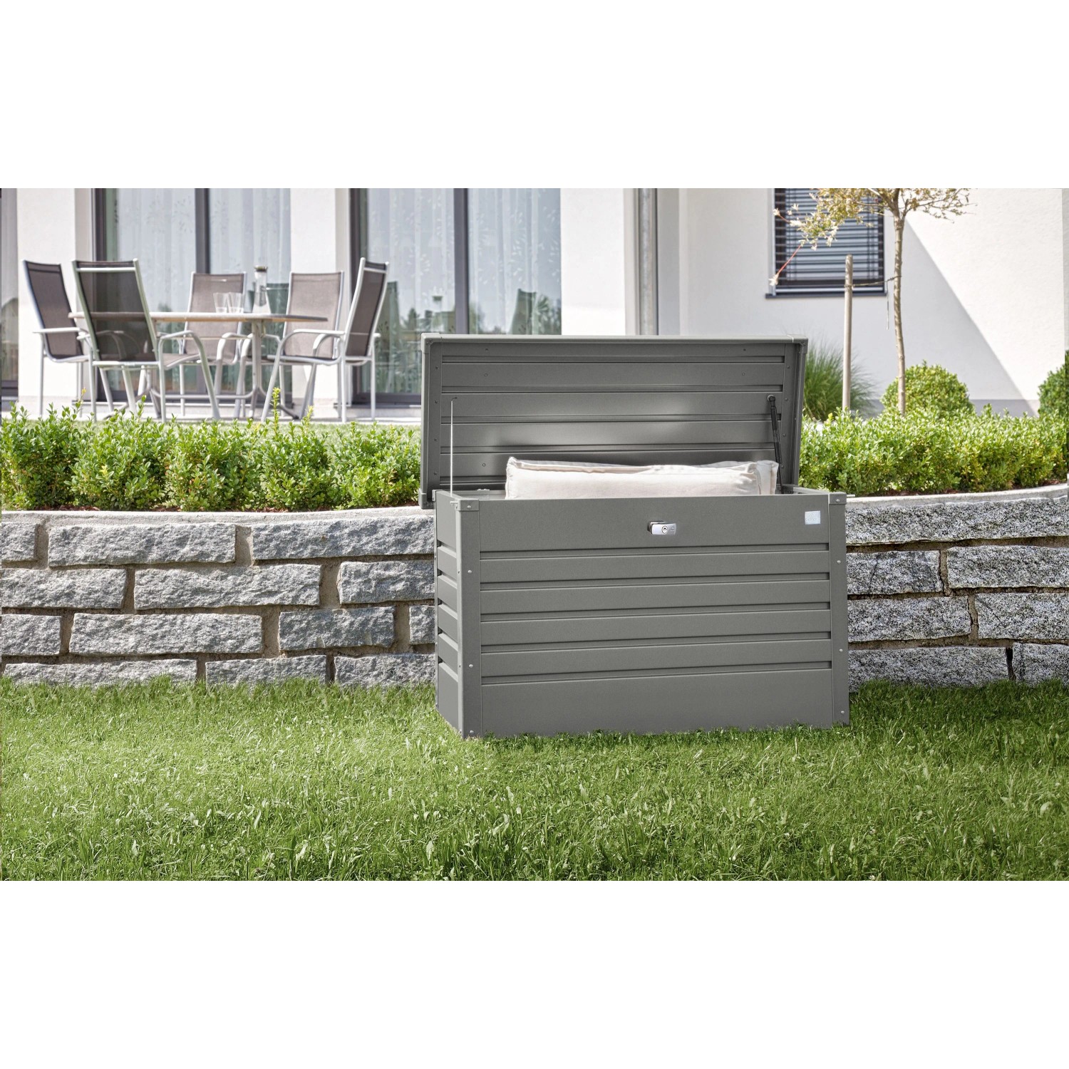 Quarzgraue Biohort FreizeitBox 100 Metallbox offen im Garten, mit Kissen. Universalbox für Outdoor.