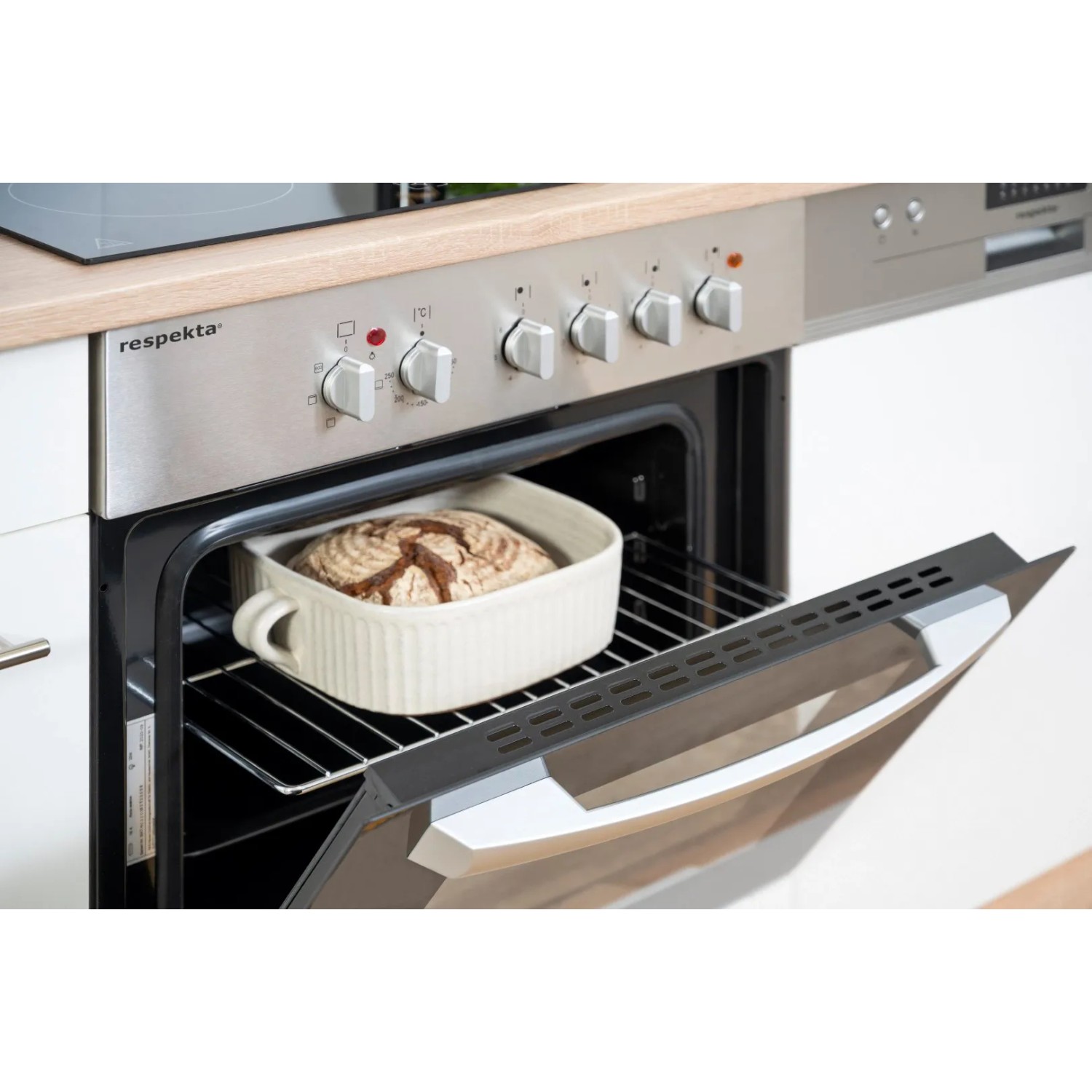 Respekta Küchenzeile mit Herd und Brotbackform im Ofen. Fronten in Weiß, Korpus Eiche Sägerau.