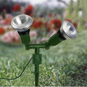Grüner 2-flammiger Gartenspot mit Erdspieß im Rasen. Gartenstrahler für E27 Leuchtmittel.