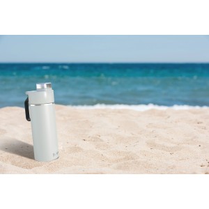 Weiße Ninja Thirsti Trinkflasche (700 ml) am Strand. Ideal für kalte Getränke, mit Thermo-Isolierung.