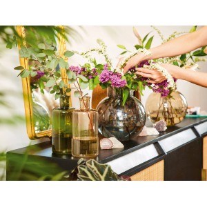 Dekorative braune Glas Vase (25,5 cm) mit Blumen auf einem Sideboard.