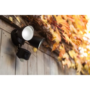 Moderne, mattschwarze Lutec LED-Kameraleuchte Draco mit zwei Leuchten und integrierter Kamera an einer Holzwand.