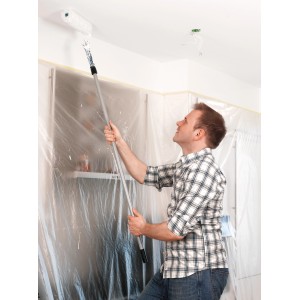 Mann streicht Decke mit Tesa Easy Cover Universal Abdeckmaterial, 2er-Pack.