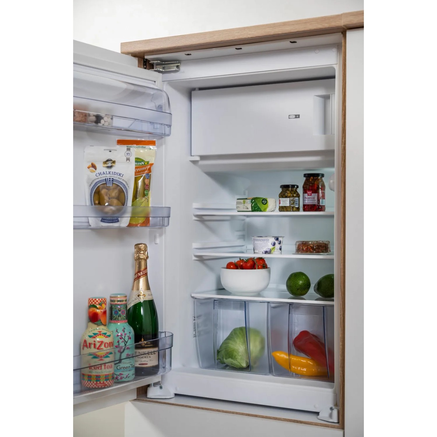 Geöffneter Kühlschrank der Respekta Küchenzeile, gefüllt mit Lebensmitteln.