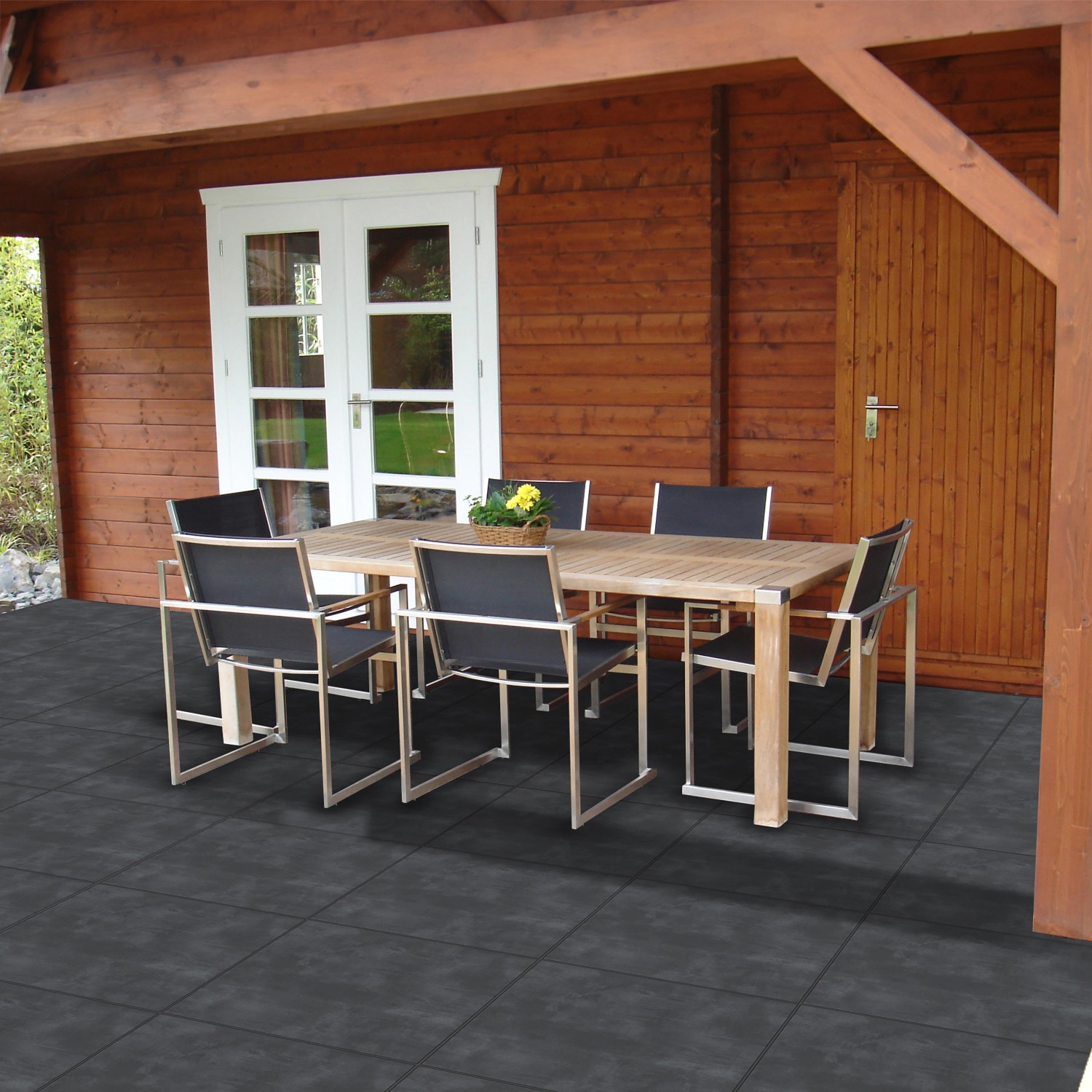 Terrasse mit grauen Feinsteinzeugplatten Streetline (60x60). Gartenmöbel auf dem Bodenbelag.