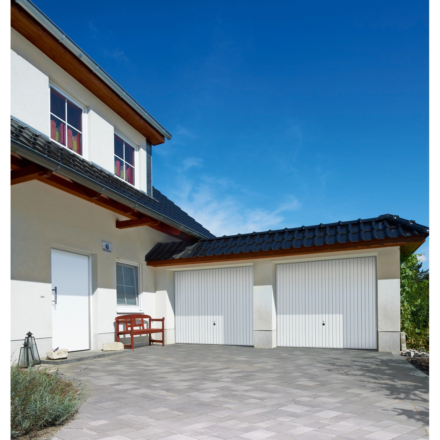 Weißes Hörmann Schwingtor Berry N80 M902 (225x192 cm) mit vertikaler Linienführung an einer Garage.