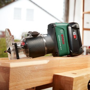 Bosch Akku-Oberfräse Advanced TrimRouter 18 V, eine Akku-Kantenfräse auf einem Werkstück.