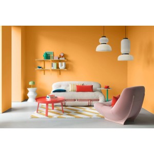 Wohnzimmer mit Wänden in Alpina Warm Apricot Orange Wandfarbe. Modernes Sofa, Sessel und Couchtisch. Helle, einladende Atmosphäre.