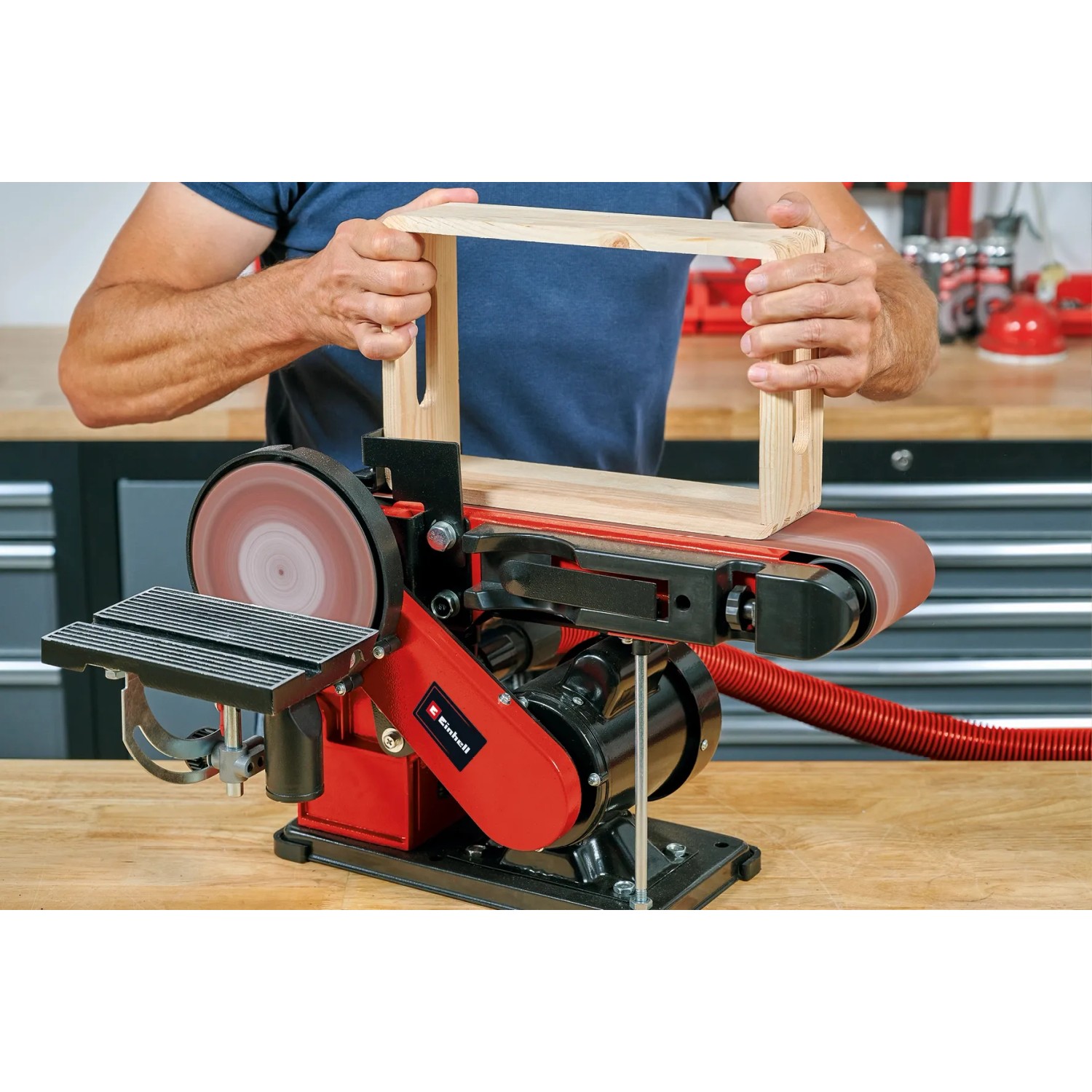 Einhell TC-US 380 Stand-Band-Tellerschleifer beim Schleifen eines Holzrahmens.
