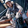 Bosch Professional Akkupack ProCore 18V/5,5 versorgt Winkelschleifer. Arbeiter schleift Metall. Leistungsstarker 18V Akku.