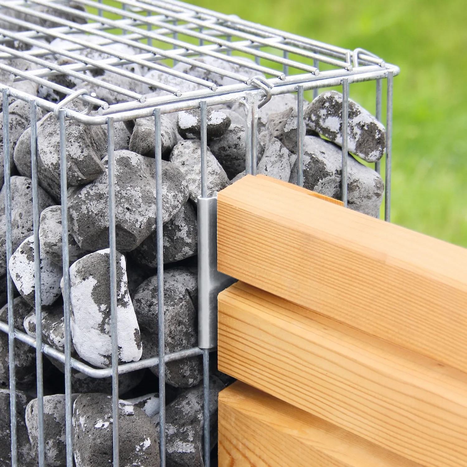 Gabionen Anbauwinkel in Silber mit Holz-Sichtschutz an einer mit Steinen gefüllten Gabione.