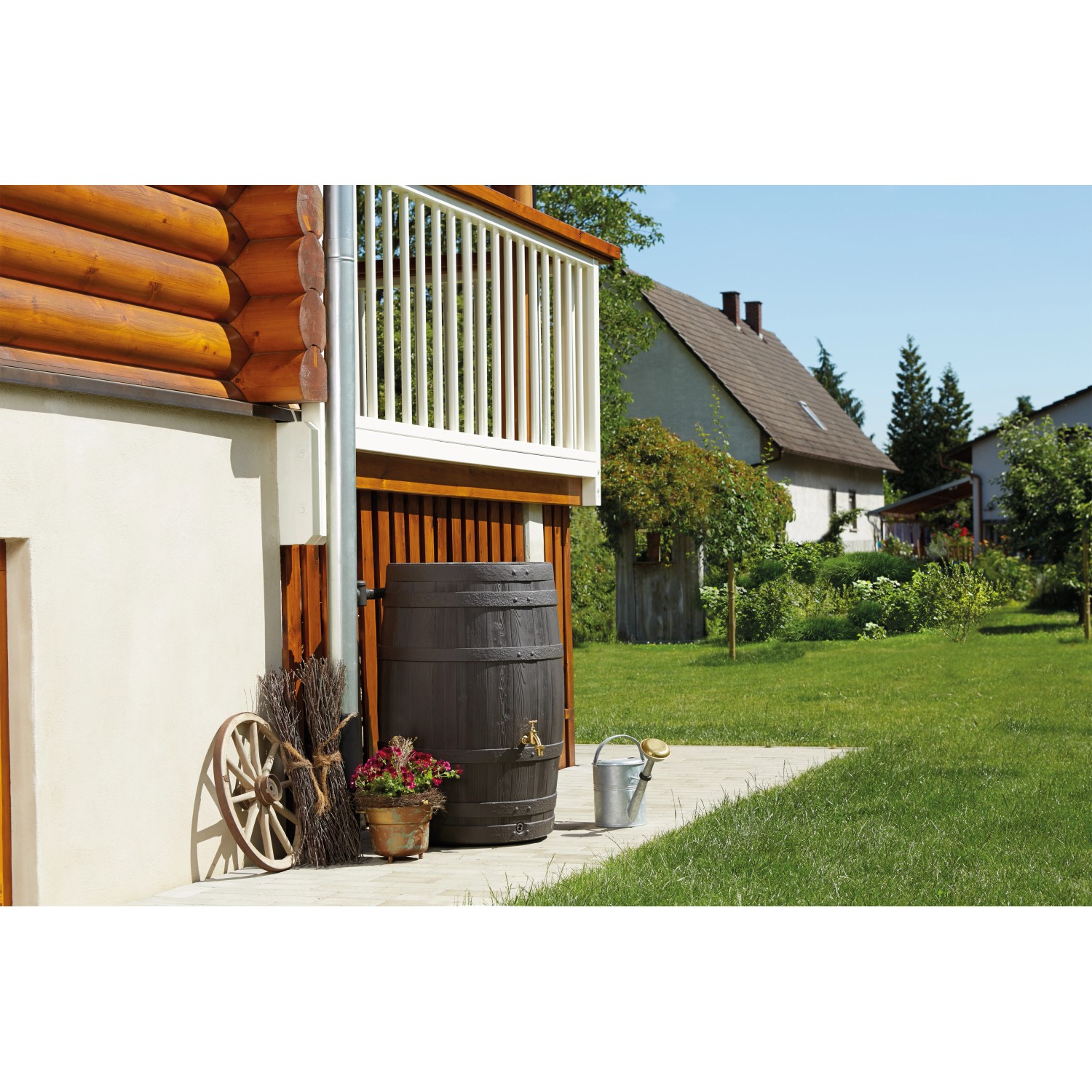Garantia Regentonne Barrica 260 l in Dunkelbraun vor Hauswand mit Garten.