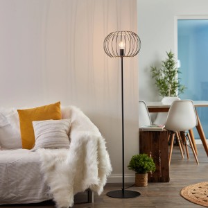 Schwarze, matte Brilliant Silemia Stehlampe mit Rattan-Schirm im Wohnzimmer.