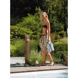 Garantia Wood Wasserzapfsäule Darkwood mit Frau und Gießkanne im Garten.