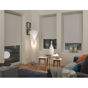 Weißes Gardinia EasyFix Thermo Rollo, energiesparend, in Wohnraum-Szene mit Couch und Lampe.