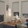 Weißes Gardinia EasyFix Thermo Rollo, energiesparend, in Wohnraum-Szene mit Couch und Lampe.