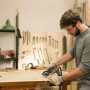 Mann sägt Holz mit Bosch Akku-Säge AdvancedCut 18. Stichsäge mit NanoBlade Technologie im Einsatz.