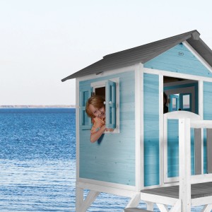 Axi Spielhaus Lodge XL in Karibikblau mit lila Rutsche, Kind schaut aus Fenster.