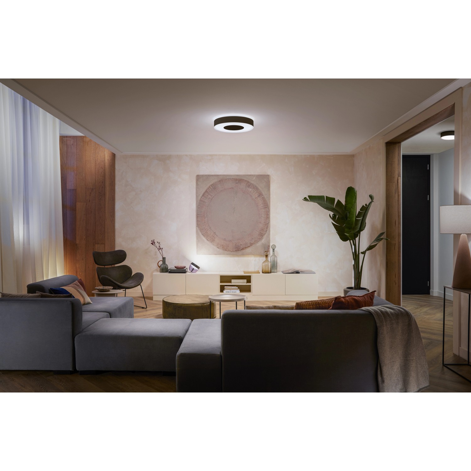 Schwarze Philips Hue Infuse L Deckenleuchte mit Farbwechsel im Wohnzimmer.