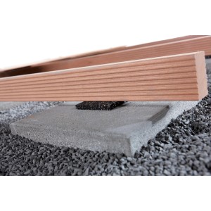 Terrassenbau Auflage-Pads unter einer Terrassendiele auf einem Stein. Abstandhalter für Unterkonstruktion.