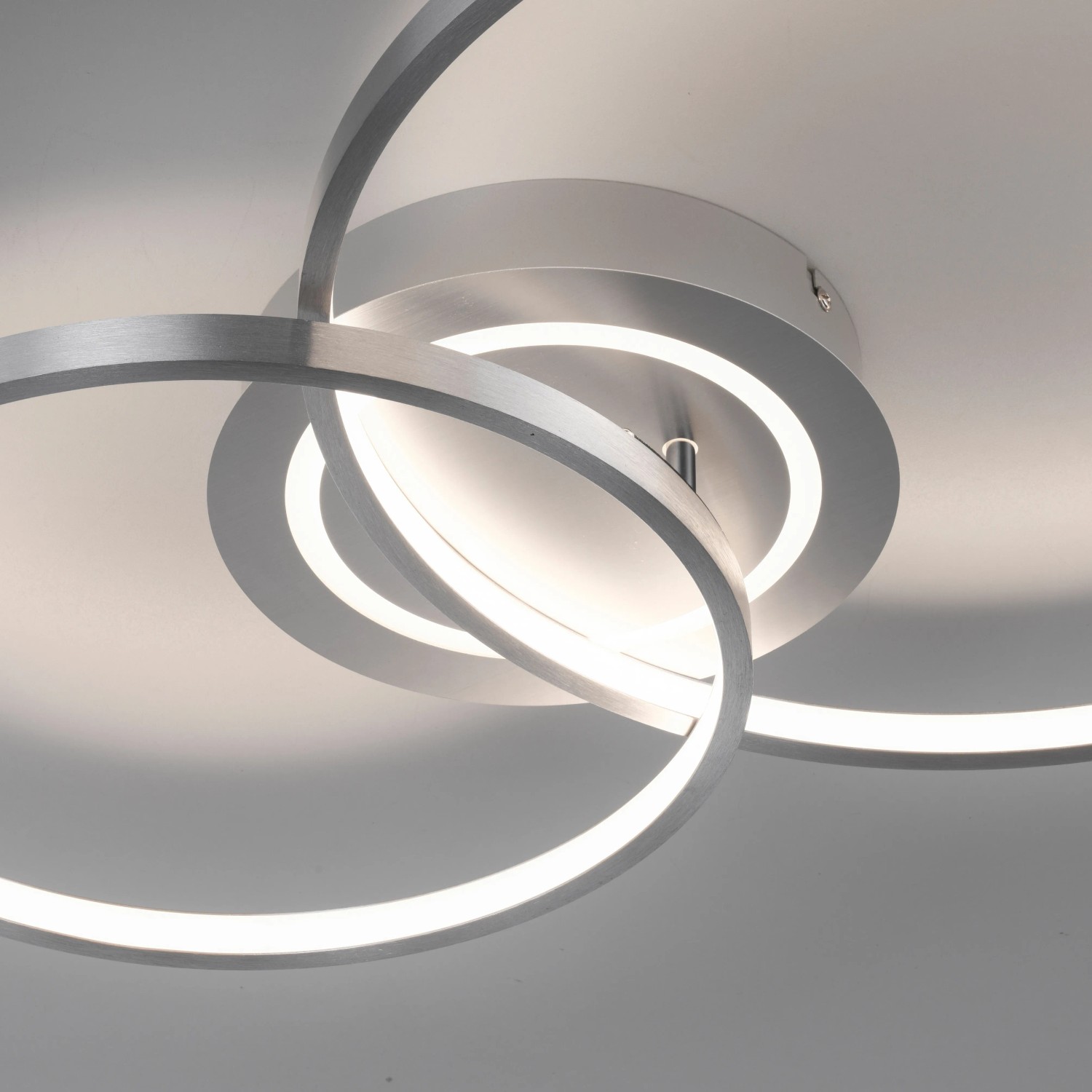 Moderne LED-Deckenleuchte Asmina aus Aluminium mit verschlungenen Ringen, warmweißes Licht.