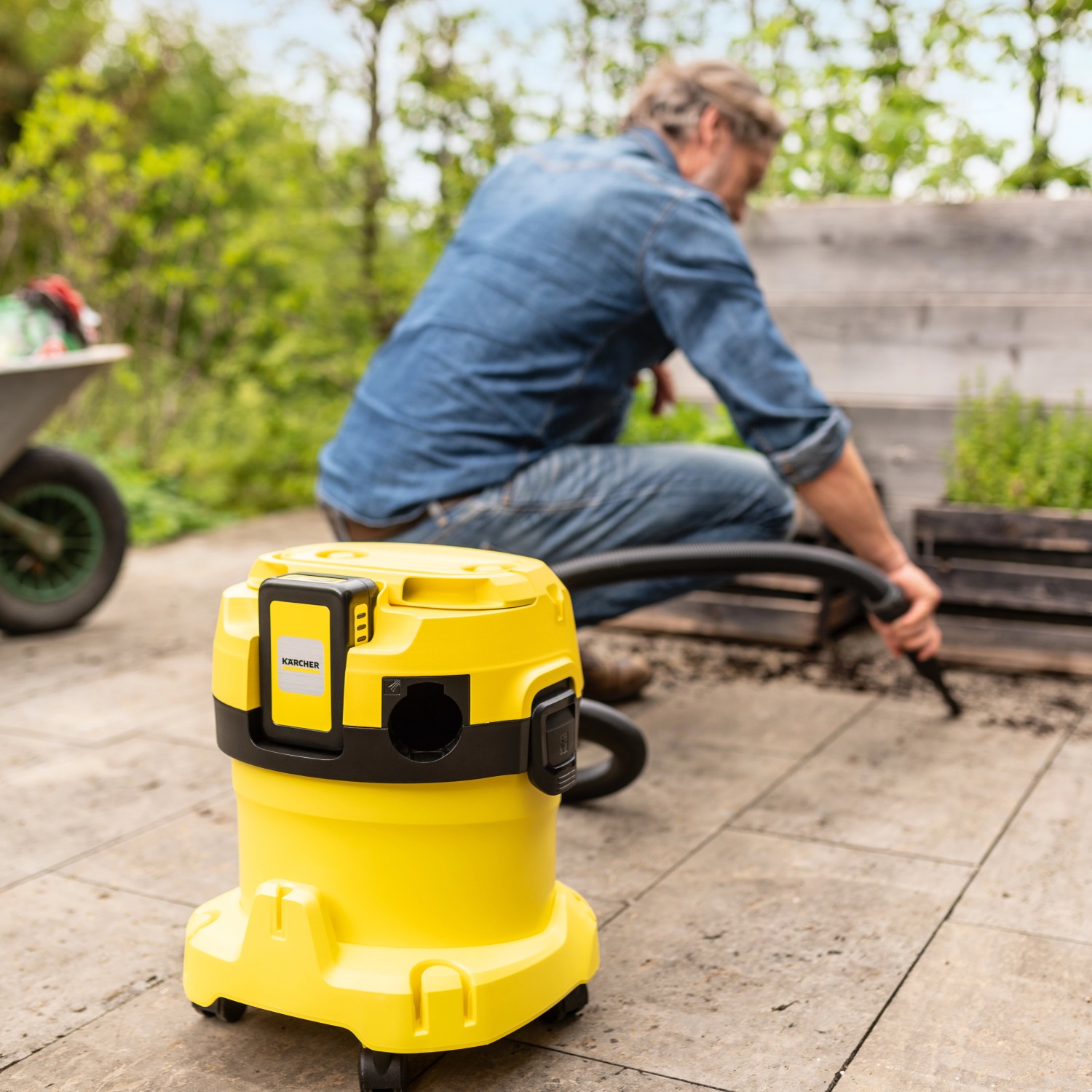 Gelber Kärcher Akku Nass-Trockensauger WD 2-18 im Außeneinsatz.