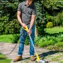 Mann benutzt Gloria Thermoflamm Bio Fix Unkrautbrenner auf Steinweg im Garten.