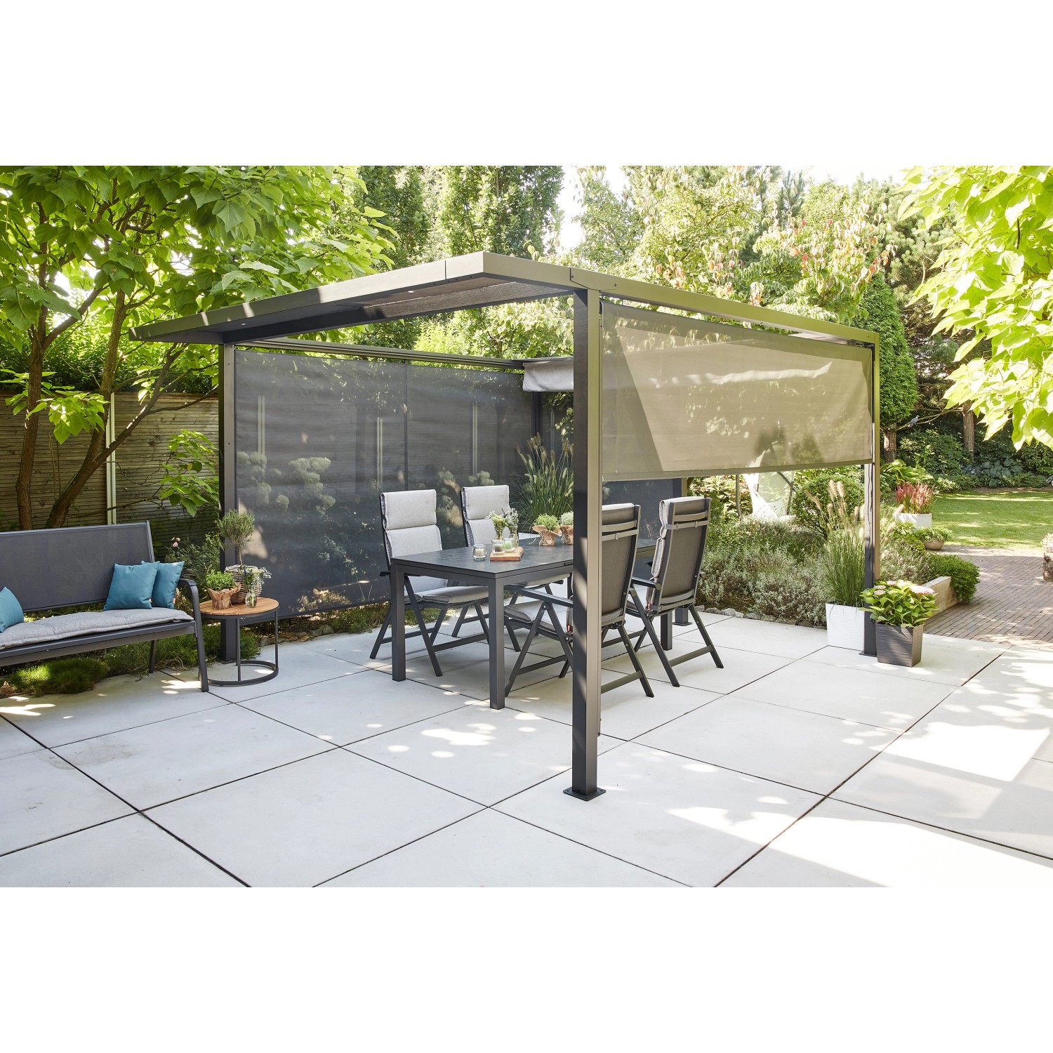 Siena Garden Pergola Schattenmanufaktur mit anthrazitfarbenem Gestell, Tisch und Stühlen im Garten.