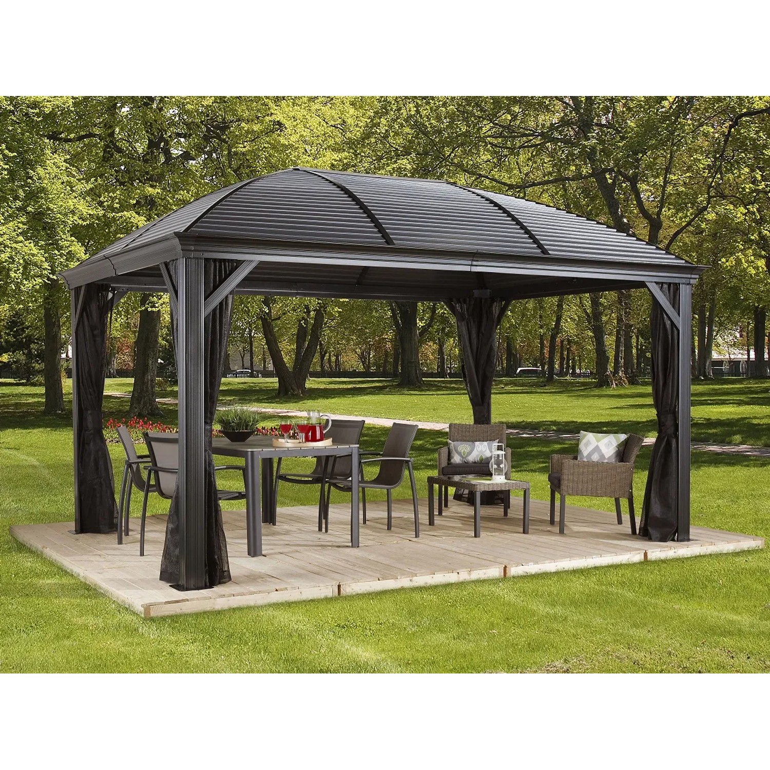 Anthrazitfarbener Sojag Pavillon Moreno 10x14 mit Moskitonetz und Gartenmöbeln auf Holzterrasse.