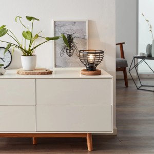 Brilliant Tischleuchte Avia in Schwarz/Holz auf Kommode. Designlampe mit Metallschirm und Holzfuß.