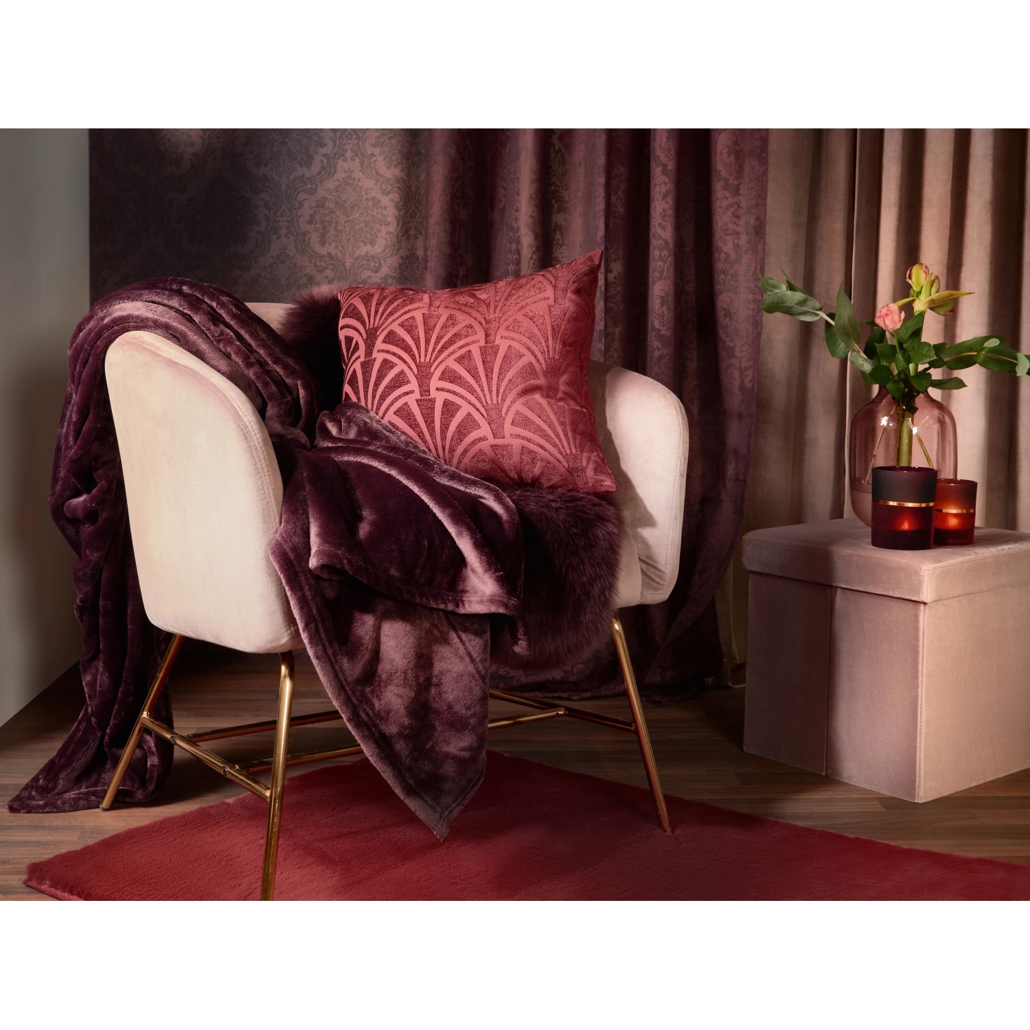 Hochflor-Teppich Blush Bordeaux (140x80 cm) auf Sessel mit Kissen und Decke im Boudoir-Stil.