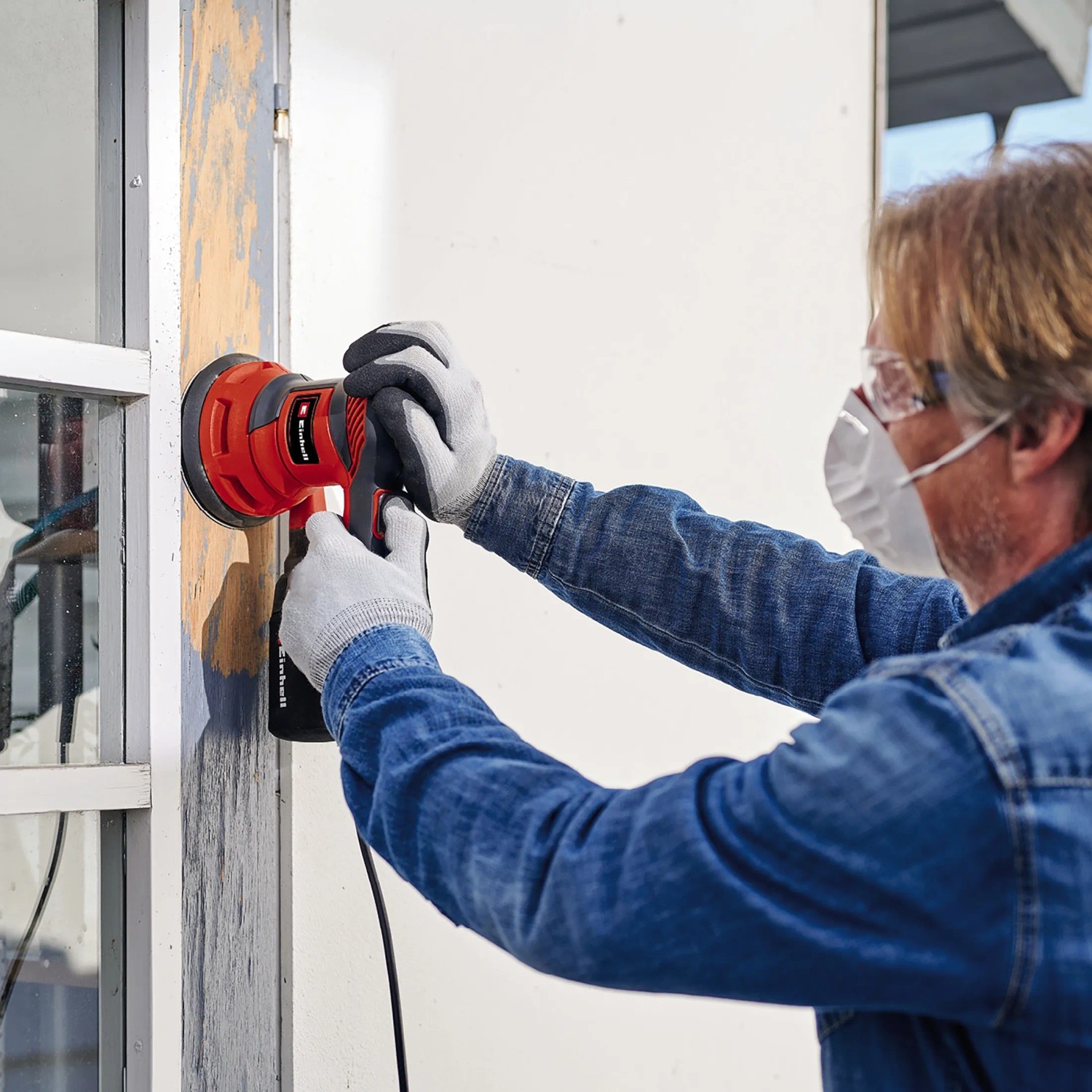 Mann schleift Fensterrahmen mit rotem Einhell Exzenterschleifer TC-RS 425 E.