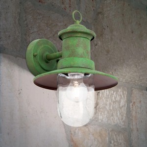 Grüne, patinierte Vintage Außenwandleuchte aus Stahl mit klarem Glasschirm an Steinwand. E27 Fassung.