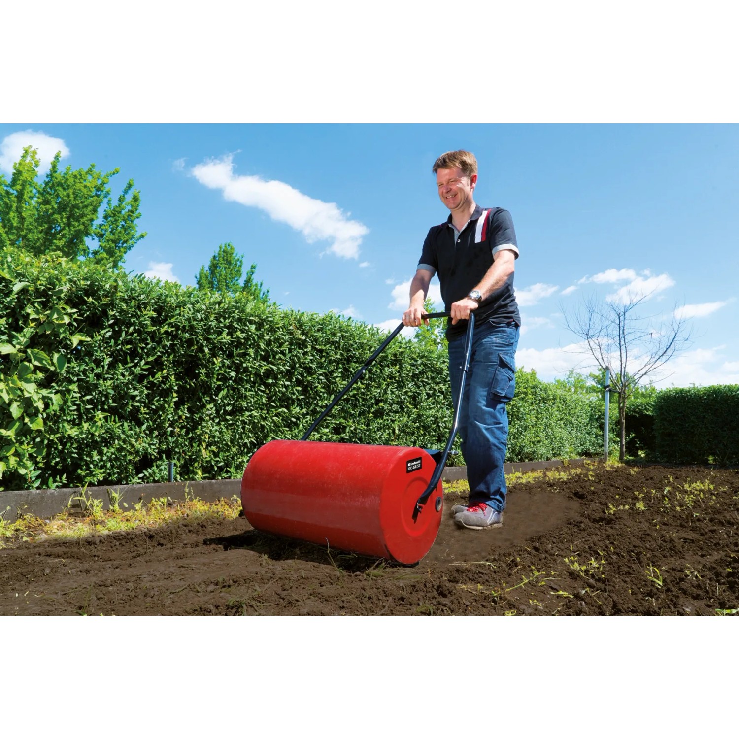 Einhell Rasenwalze GC-GR 57 im Einsatz: Rote Gartenwalze zum Verdichten von Erde und Saatgut.