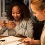 Szene mit zwei jungen Frauen an einem Tisch, beleuchtet durch eine Philips E27 LED Lampe.