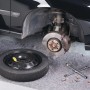 Graues LUX Abdeckvlies 1x3m unter Auto mit Reifen und Werkzeug als Schutz.